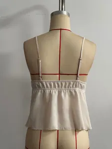 Back view detail of a chic beige camisole featuring delicate straps and smocked bodice.