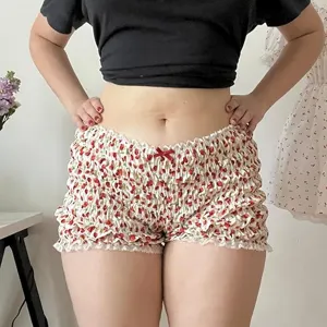 Vista dettagliata degli shorts a vita bassa arricciati con stampa carina e fiocco.