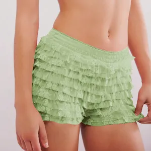 Detail shot of women's low-waist tiered ruffle shorts in light green, showcasing layered design.