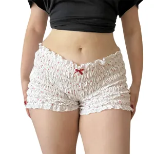 Vista dettagliata di pantaloncini a vita bassa arricciati con volant, fiocco rosso e stampa.