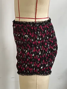 Vista dettagliata di pantaloncini corti da donna con stampa ciliegie e bordo in pizzo.