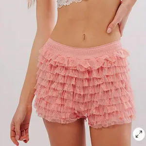 Pink layered ruffle lace shorts detail showcasing the textured tiered mesh design and waistline.