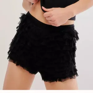 Black ruffle mesh shorts detail view showing tiered layers and elastic waistband texture.