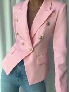 Detalle de chaqueta blazer cruzada rosa con lujosos botones dorados y corte entallado.