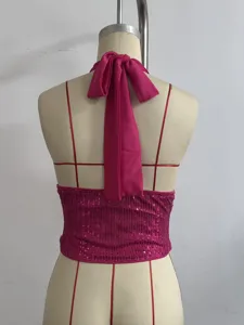 Pink sequin halter crop top back view showing the bow tie detail and sparkling fabric texture.