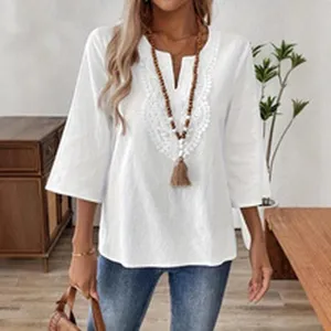 Close-up detail of women's white V-neck hollow lace blouse showcasing delicate embroidery craft.