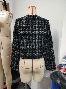 Λεπτομέρεια πίσω όψης του chic ασπρόμαυρου σακακιού tweed με καθαρή ραφή.