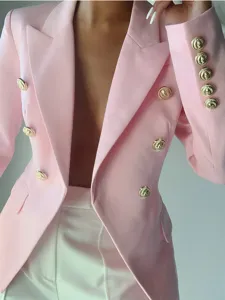 Blazer rosa cruzado con botones dorados en relieve, corte entallado vista de detalle.