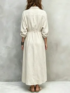 Detailed view of casual beige long sleeve shirt dress with drawstring waist and collar.