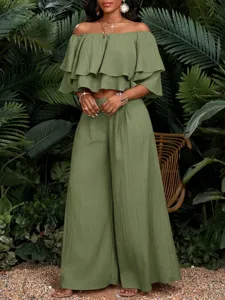 Detailansicht des olivgrünen schulterfreien Rüschen-Crop-Tops und der weiten Hosen.