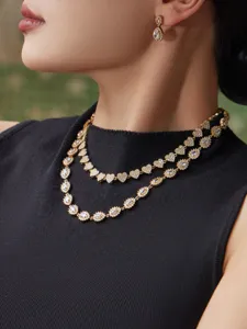 Primer plano detallado de lujoso collar de circonitas brillante y pendientes dorados.