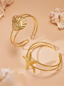 Roestvrijstalen gouden ocean stijl zeester en schelp open armbanden detailweergave textuur.