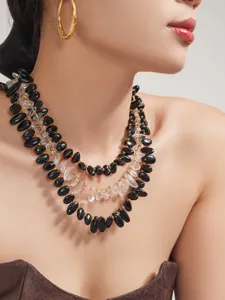 Nahaufnahme der mehrreihigen Perlenkette aus schwarzem Achat und Kristall mit Goldteilchen.