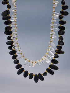 Detailaufnahme der zweilagigen Perlenkette mit schwarzem Onyx, Bergkristall und vergoldeten Perlen.
