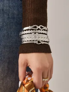 Silver stackable bracelets set featuring floral texture and geometric buckle designs.