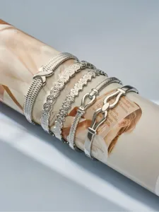 Detailed view of luxury stainless steel layered bracelets with geometric and floral textures.