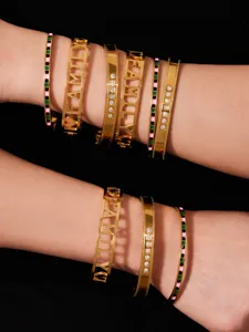 Stylish stainless steel gold-plated bangle bracelets featuring zirconia and family cutout designs.