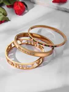 Detail view of a stylish stainless steel PVD gold-plated bangle set featuring zircon and enamel.