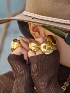 Gold statement dome ring detail, bold geometric metal finger jewelry for modern women.