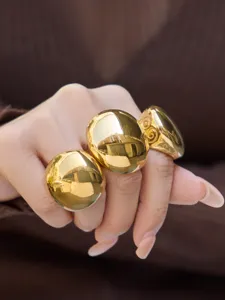 Gold statement dome ring close-up, chunky smooth geometric finger jewelry detail shot.