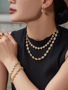 Set de joyas de acero inoxidable elegante con circones brillantes de corazon y gota.