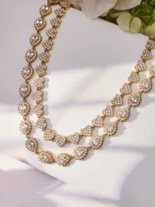 Vista detallada de primer plano de collar de oro con circonitas en forma de corazon.