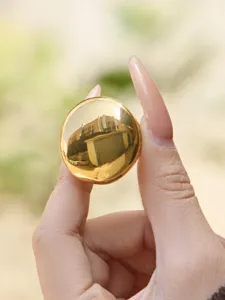 Detailed shot of a chic gold-tone large round ball geometric ring, smooth wide surface design.