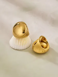 Detailed shot of the chic teardrop gold statement ring, showcasing smooth dome and engraved sides.