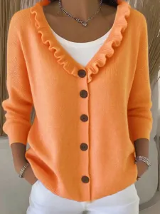 Detail shot of orange V-neck knit cardigan featuring elegant ruffles and brown button closure.