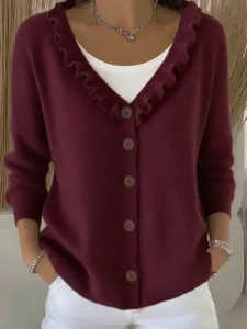 Detail shot of women's burgundy V-neck cardigan with ruffled collar and button front.