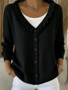 Detailed view of women's black cardigan featuring ruffled v-neck, chic buttons, and knit texture.