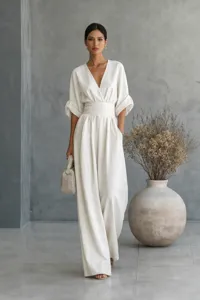 Elegante witte jumpsuit model scène met V-hals, getailleerde taille en breed beenontwerp.