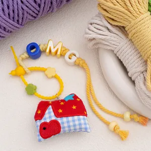 Handmade DIY keychain charm featuring cute mini house pendant and colorful braided cords.