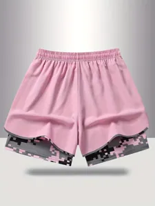 Detailed view of women's fake two-piece athletic shorts in pink with pixel camo inner layer.