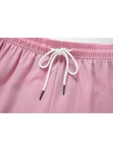 Pink casual shorts detail featuring elastic waistband and white drawstring with metal tips.
