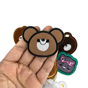 Close-up detail of cartoon bear embroidered patch, fine stitching for apparel decor.