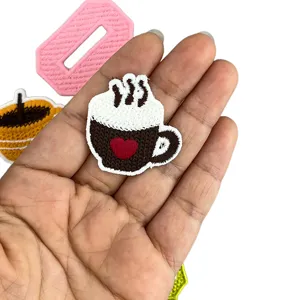 Detailed view of cute embroidered coffee cup patch, perfect for DIY clothing decoration.