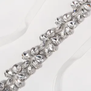 Detailed close-up view of luxury crystal rhinestone bridal belt decorated with white ribbon sash.