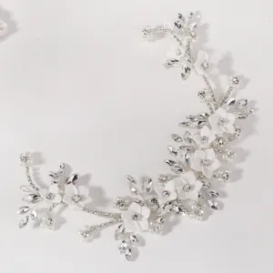Close-up detail van witte keramische bloem bruids haarwijnstok met sprankelende strass parels.