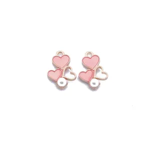 Detailed view of pink heart enamel alloy charm with pearl accent for DIY jewelry.