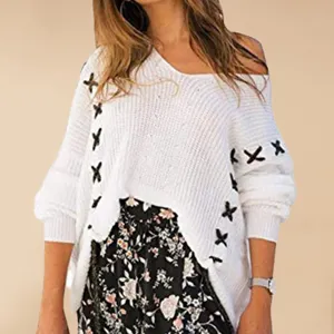 Detailed close-up showing the stylish cross-laced sleeve design on a cozy white knit sweater.