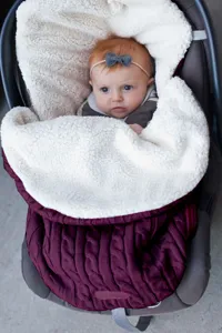 Gemütlicher Strick Babyschlafsack mit weichem Sherpa Futter für warme Kinderwagen Fahrten.