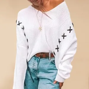 Detailed view of white off-shoulder knitted sweater with cross lace-up sleeves for women.