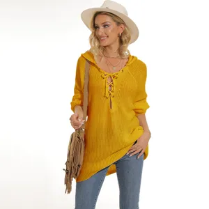 Detalle de primer plano del suéter de punto amarillo con cordones y capucha cómoda.
