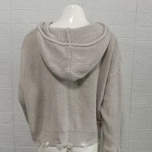 Detailed view of the back of a women's knitted hooded sweater with distressed hem design.