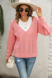 Primo piano dettagliato che mostra il cardigan in maglia rosa con motivo traforato nella scena.