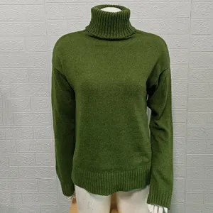 Detail view of a solid green women's turtleneck sweater with ribbed collar and cuffs knit.