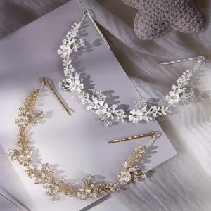 Detail bruid haaraccessoire met zilveren en gouden strass bloemen metaal ranken en spelden.