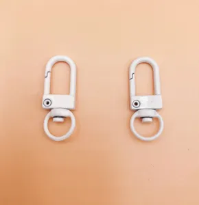 Metal painted dog clips detail, white zinc alloy keychain hardware accessory close-up view.