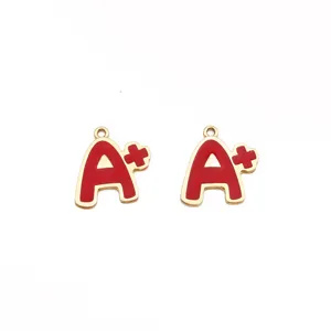 Primer plano de dijes colgantes de aleación esmaltada A+ rojo y dorado para joyería de bricolaje.